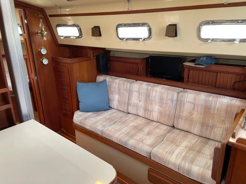 Slide: The Image of Interior of 1992 Island Packet 32 sailboat with cozy seating and wooden accents. - 18