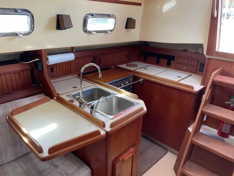 Slide: The Image of Interior of 1992 Island Packet 32 sailboat galley with wooden cabinetry and stainless steel sink. - 20