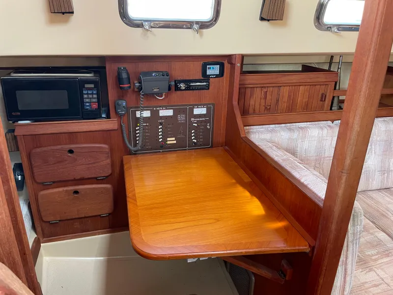 Slide: The Image of 1992 Island Packet 32 interior with navigation station, microwave, and wooden cabinetry. - 23