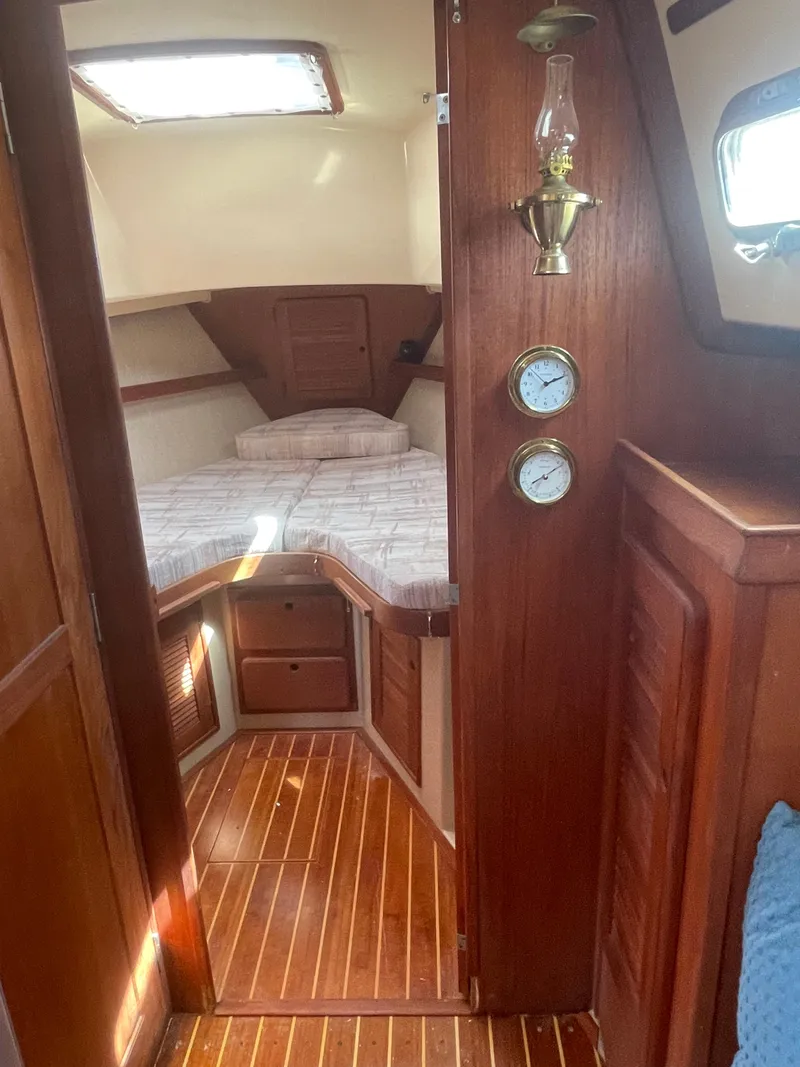 Slide: The Image of Interior of 1992 Island Packet 32 sailboat with wood finish and cozy sleeping area. - 26