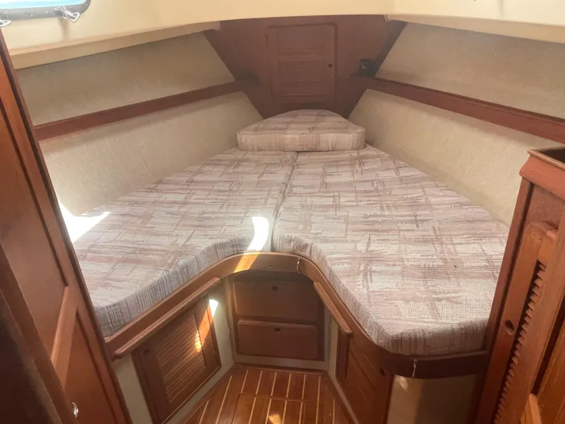 Slide: The Image of 1992 Island Packet 32 sailboat interior cabin with V-berth and wooden accents. - 27