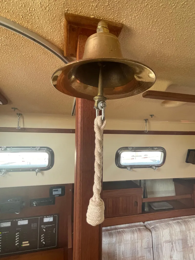 Slide: The Image of Brass bell inside 1992 Island Packet 32 sailboat cabin with wooden interior. - 30