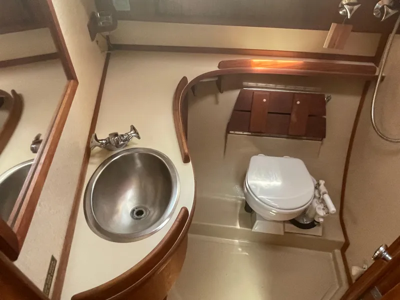 Slide: The Image of 1992 Island Packet 32 yacht bathroom with sink, toilet, and wooden accents. - 32