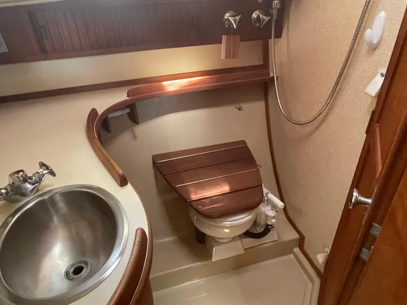 Slide: The Image of 1992 Island Packet 32 yacht bathroom with sink, toilet, and wooden accents. - 33