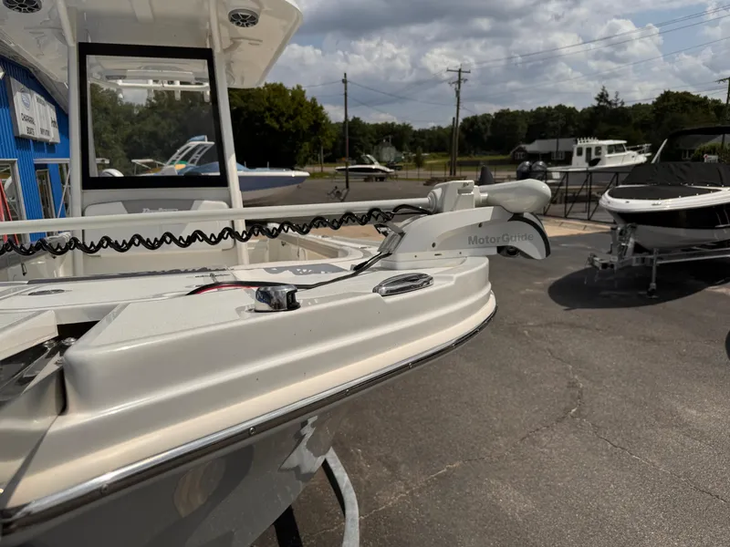 Slide: The Image of 2025 Parker 2200 Center Console boat with trolling motor, displayed outdoors on a sunny day. - 23