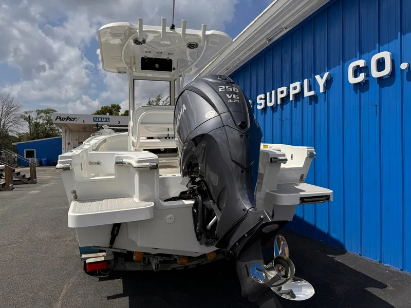 Slide: The Image of 2025 Parker 2200 Center Console boat with Yamaha engine, parked near blue building. - 4