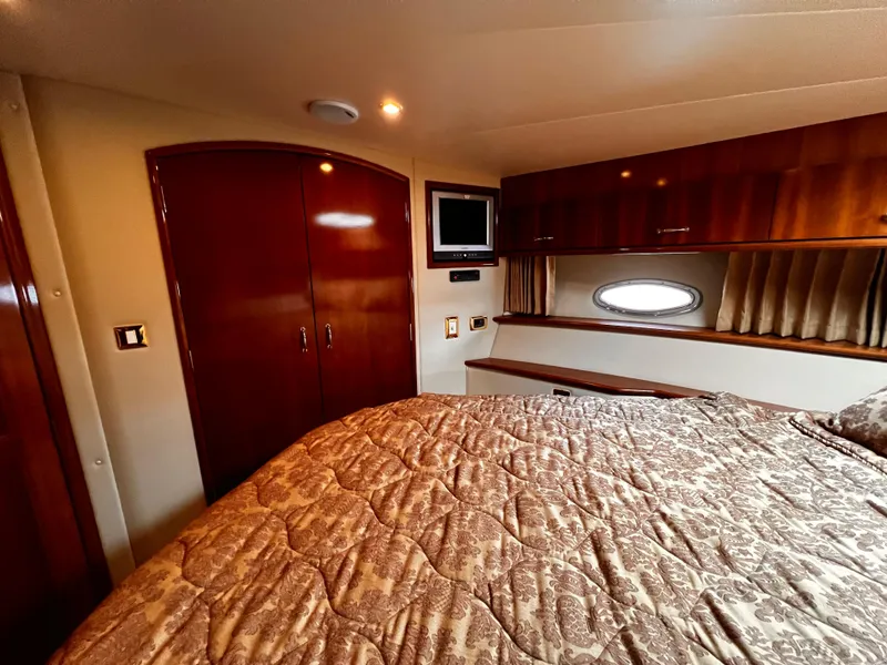 Slide: The Image of Luxurious bedroom interior of 2005 Carver 466 Motor Yacht with wood finishes and cozy bedding. - 14