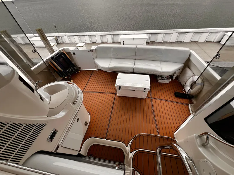 Slide: The Image of 2005 Carver 466 Motor Yacht deck with seating and cooler, overlooking water. - 2