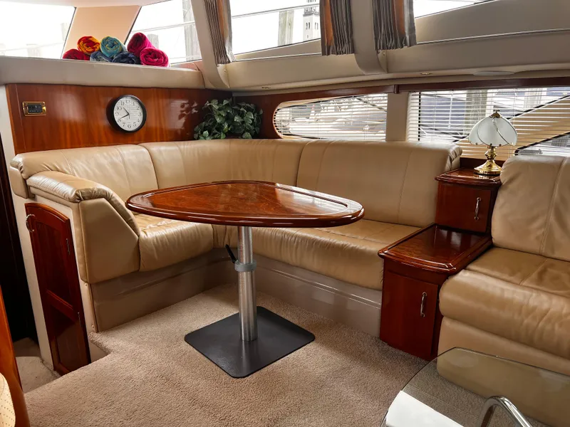 Slide: The Image of Luxurious interior of 2005 Carver 466 Motor Yacht with leather seating and wooden table. - 3