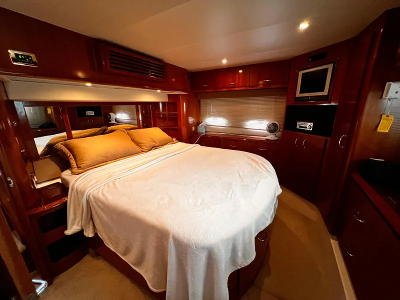 Slide: The Image of Luxurious bedroom interior of 2005 Carver 466 Motor Yacht with wood finishes and cozy bedding. - 4