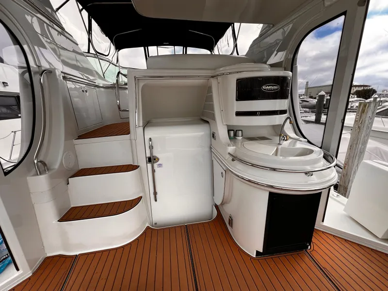 Slide: The Image of 2005 Carver 466 Motor Yacht interior with kitchenette and stairs, featuring sleek design and wood flooring. - 6