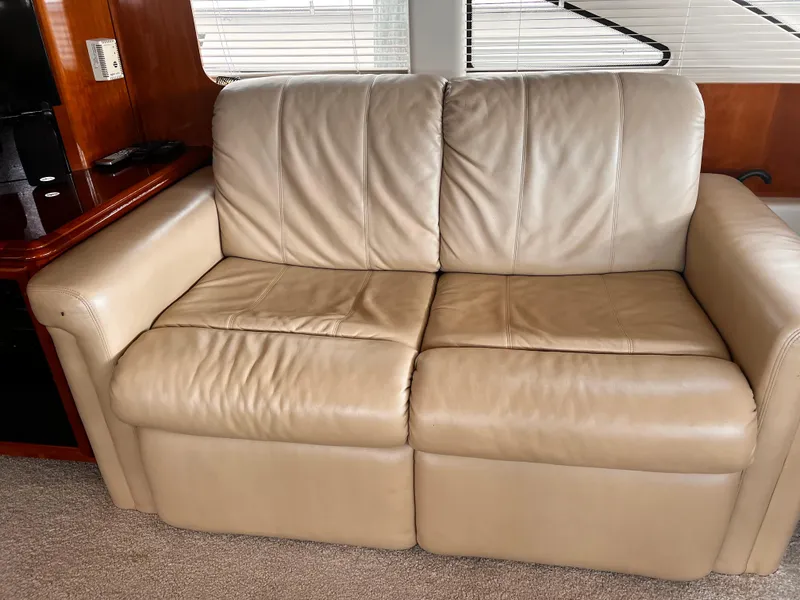 Slide: The Image of Beige leather sofa inside 2005 Carver 466 Motor Yacht, with wooden paneling and carpeted floor. - 8