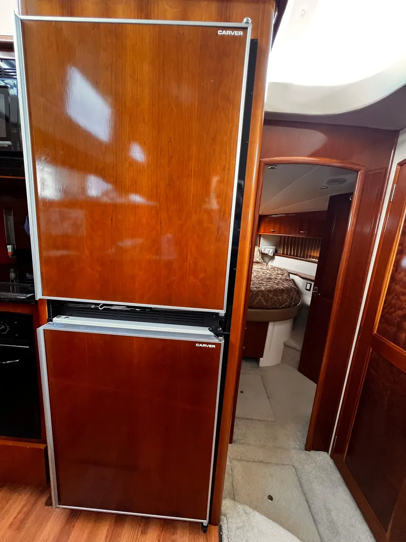 Slide: The Image of Interior of 2005 Carver 466 Motor Yacht with wood-paneled refrigerator and cozy bedroom. - 9