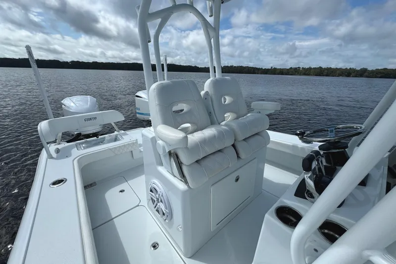 Slide: The Image of 2020 Costa Custom Boats 264 HC interior with white seating on a calm lake. - 19