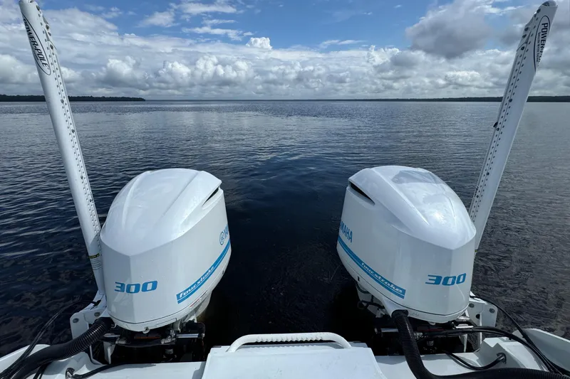 Slide: The Image of Twin outboard engines on a 2020 Costa Custom Boats 264 HC, overlooking a serene lake. - 22
