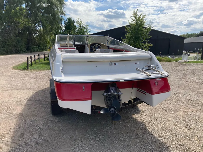 Slide: The Image of 1994 Four Winns 210 Horizon boat, rear view, parked on gravel driveway. - 2