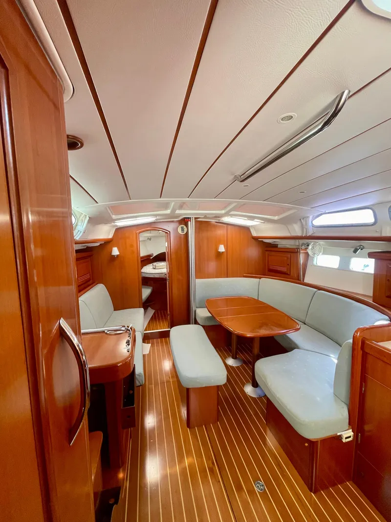 Slide: The Image of Interior of 2007 Beneteau 423 sailboat with wood finish and cushioned seating. - 33