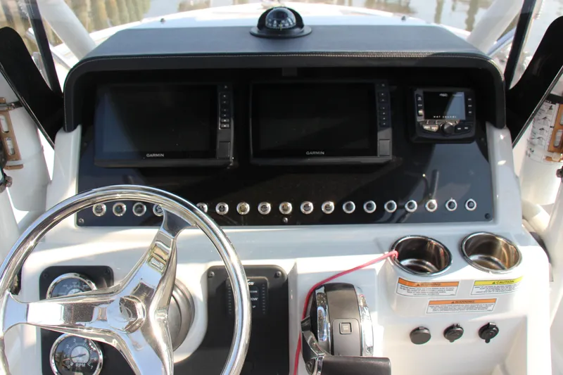 Slide: The Image of 2022 Finseeker 230 CC boat dashboard with steering wheel and navigation screens. - 10