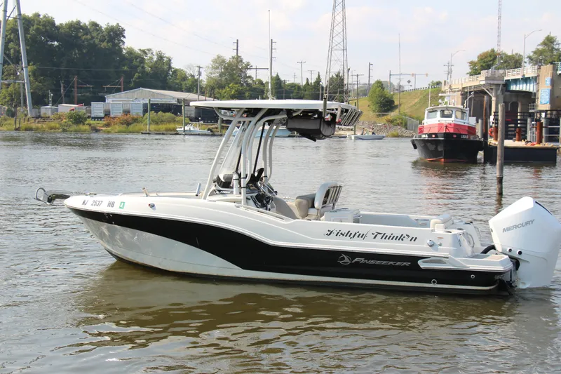 Slide: The Image of 2022 Finseeker 230 CC boat on a river, featuring sleek design and powerful engine. - 19