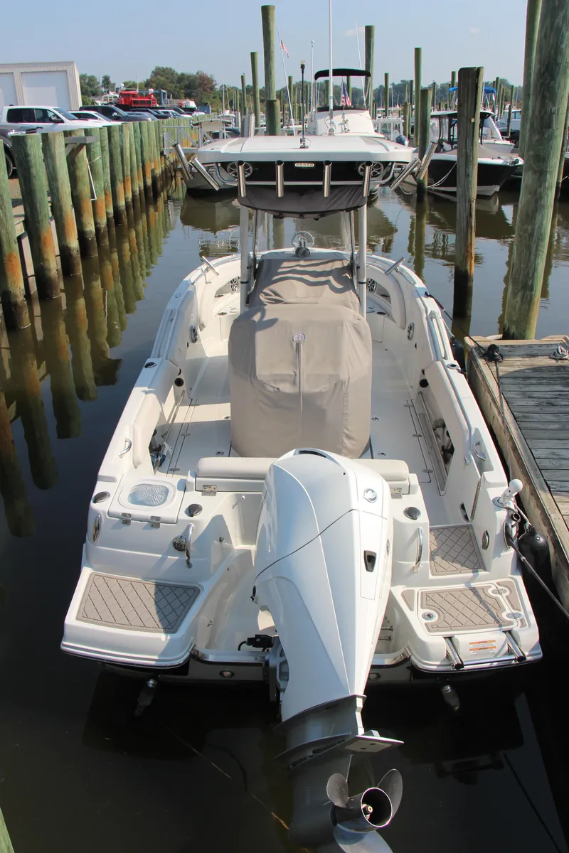 Slide: The Image of 2022 Finseeker 230 CC boat docked, rear view with outboard motor. - 2