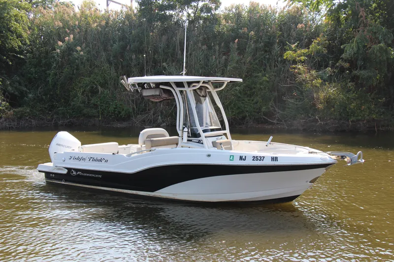 Slide: The Image of 2022 Finseeker 230 CC boat on a calm river, surrounded by lush greenery. - 23