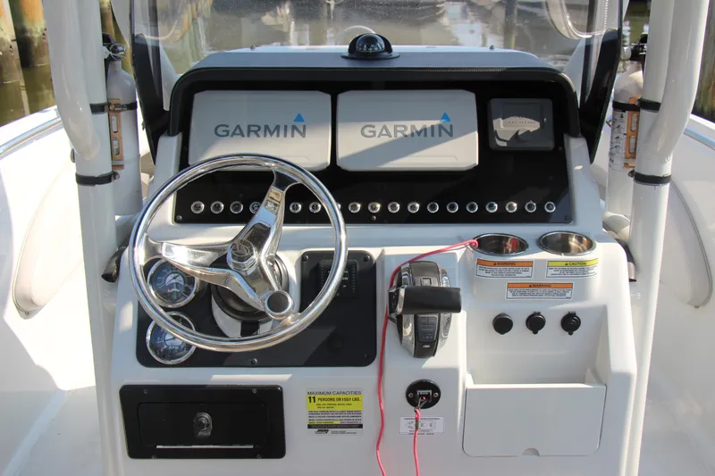 Slide: The Image of Finseeker 230 CC 2022 boat dashboard with Garmin displays and steering wheel. - 5