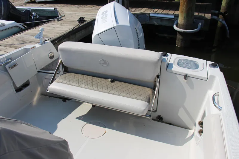 Slide: The Image of 2022 Finseeker 230 CC boat interior with cushioned seating and outboard motor. - 6