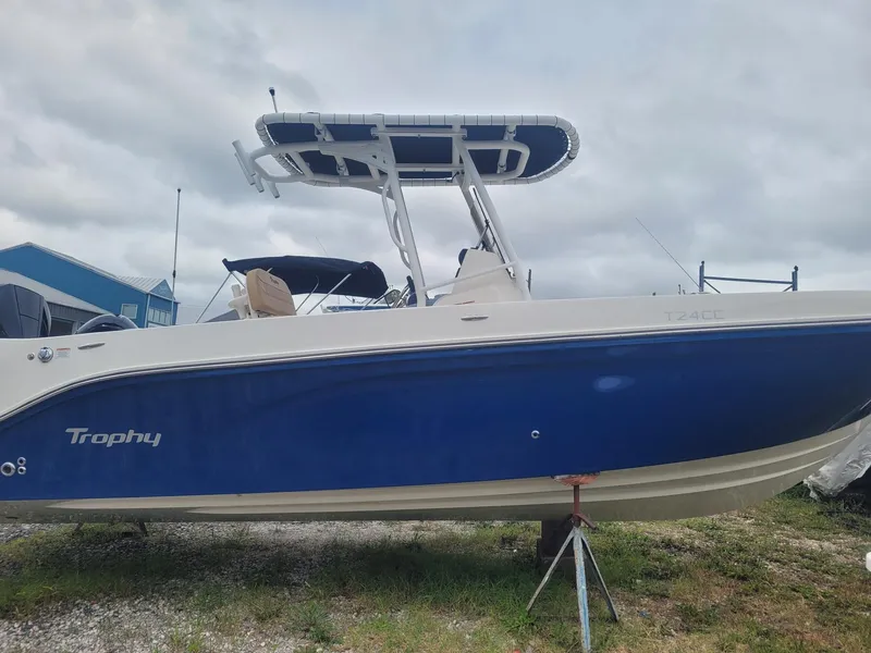 The Image of 2024 Bayliner Trophy T24CC boat with blue hull on display outdoors. - 0