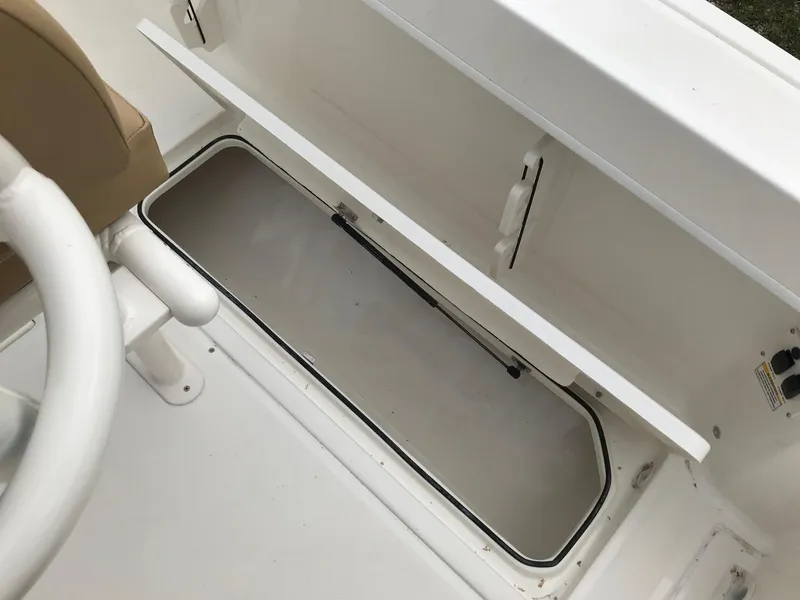 Slide: The Image of 2024 Bayliner Trophy T24CC storage compartment with open lid, showcasing interior space. - 12