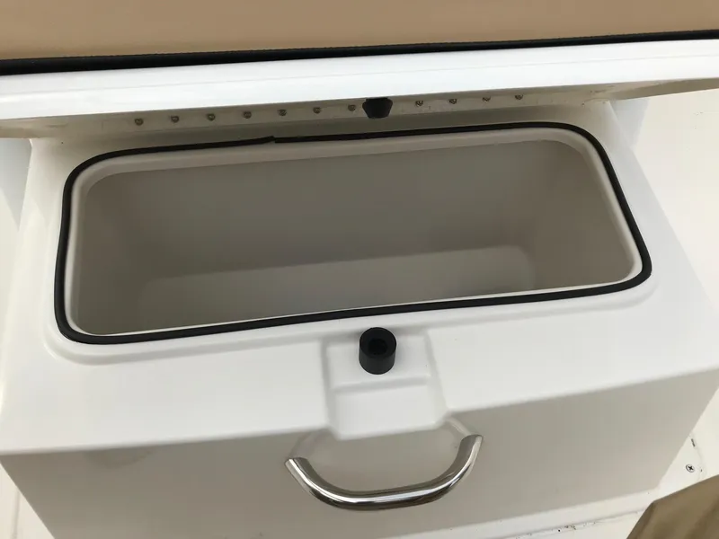 Slide: The Image of 2024 Bayliner Trophy T24CC storage compartment with handle, open lid view. - 14
