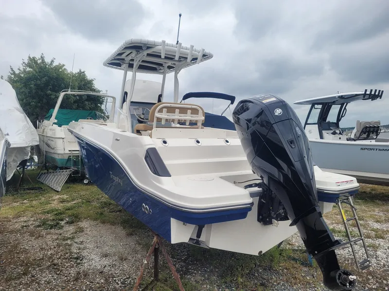 Slide: The Image of 2024 Bayliner Trophy T24CC boat with outboard motor, parked outdoors. - 4