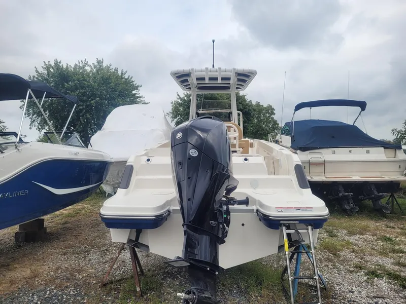 Slide: The Image of 2024 Bayliner Trophy T24CC boat with outboard motor, parked outdoors. - 5