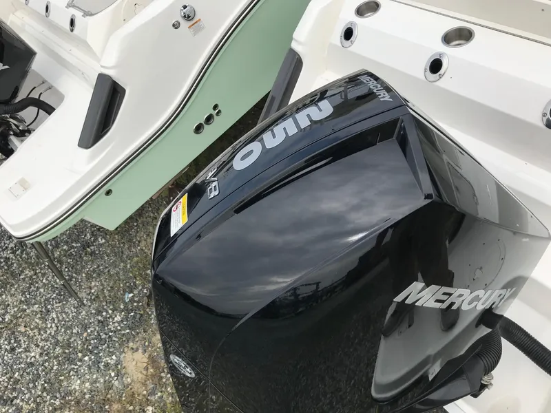 Slide: The Image of 2024 Bayliner Trophy T24CC with Mercury outboard motor, docked on gravel surface. - 6