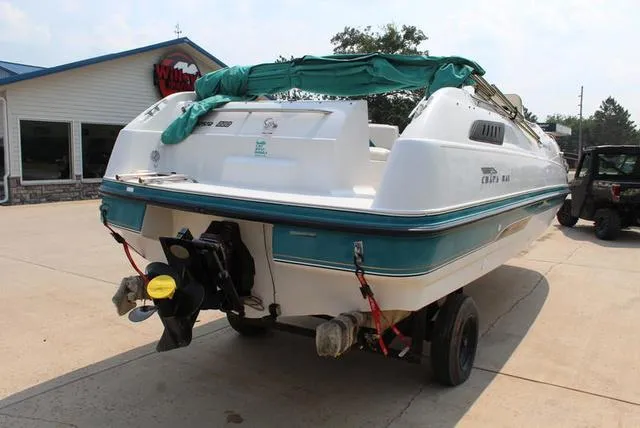 Slide: The Image of 1994 Chaparral 220 Sunesta Deck boat on trailer, parked outside a building. - 3