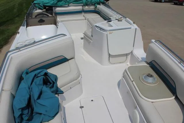 Slide: The Image of 1994 Chaparral 220 Sunesta Deck boat interior with white seating and teal accents. - 9