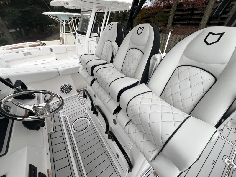 Slide: The Image of 2025 Sea Fox 328 Commander boat interior with luxurious white seating and modern steering wheel. - 6