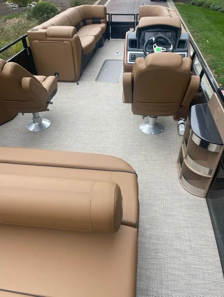 Slide: The Image of 2024 Regency 250 LE3 Sport boat interior with tan seating and modern dashboard. - 2