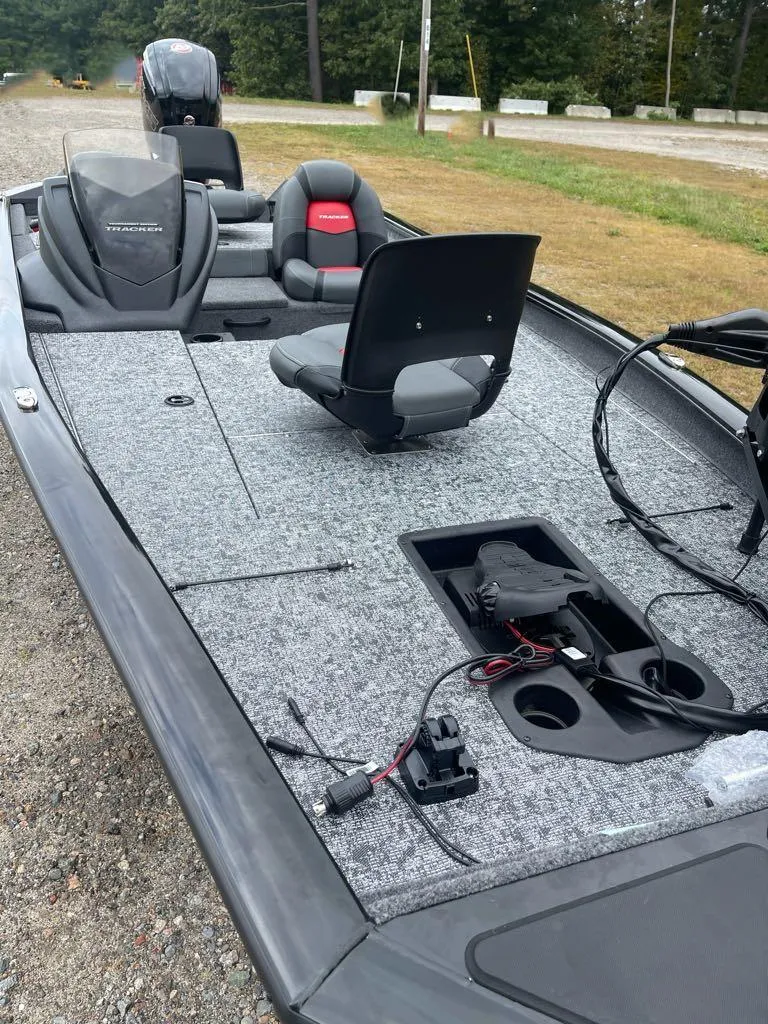 Slide: The Image of 2025 Tracker Pro Team 190 fishing boat with seating and storage on gravel path. - 3