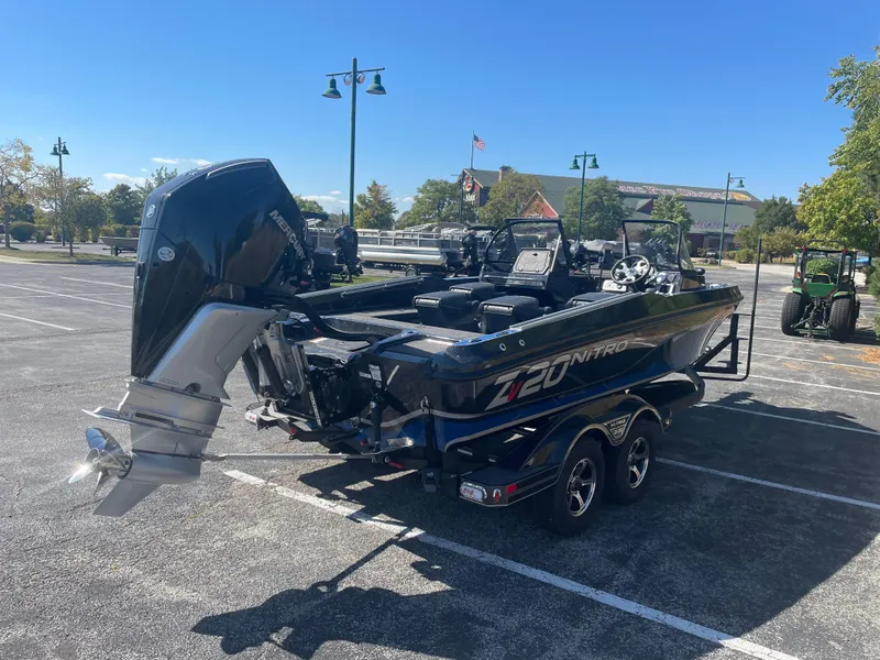 Slide: The Image of 2024 Nitro ZV20 Pro boat in parking lot, rear view, showcasing powerful outboard motor. - 2