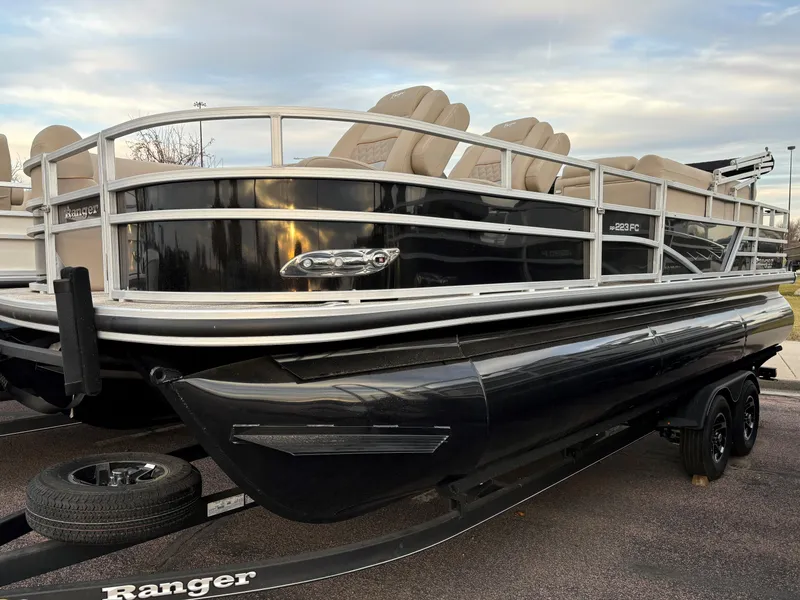 Slide: The Image of 2024 Ranger Reata 223FC pontoon boat with sleek black exterior and comfortable seating. - 0