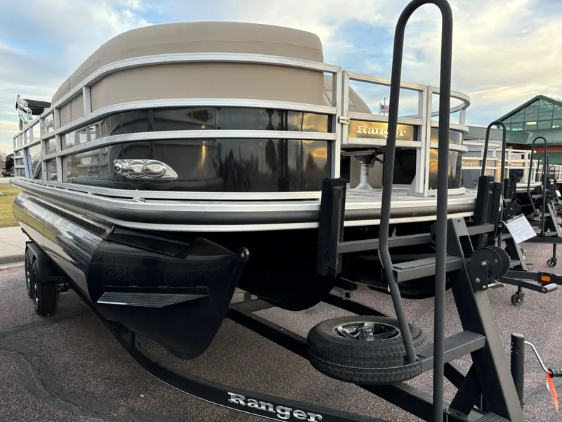 Slide: The Image of 2024 Ranger Reata 223FC pontoon boat on trailer, outdoor display. - 1