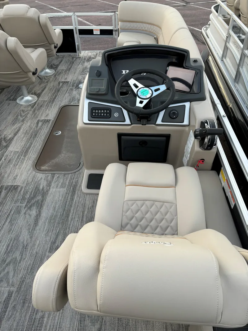Slide: The Image of 2024 Ranger Reata 223FC boat interior with beige seating and modern dashboard. - 10