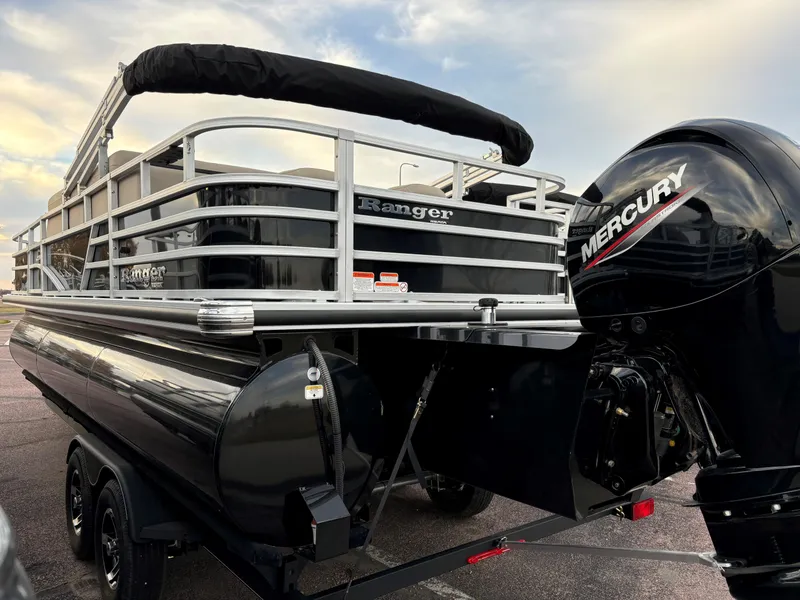 Slide: The Image of 2024 Ranger Reata 223FC pontoon boat with Mercury engine, sleek black design. - 2