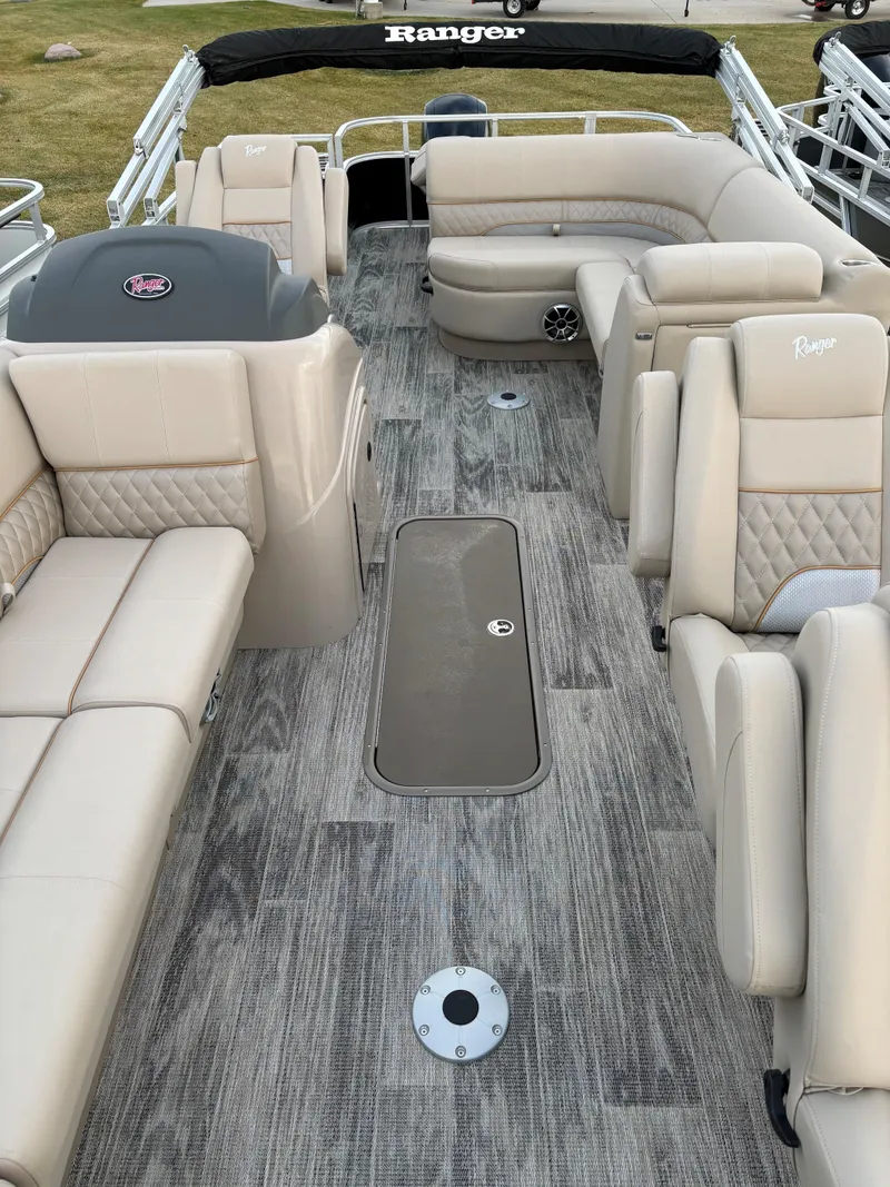 Slide: The Image of 2024 Ranger Reata 223FC boat interior with beige seating and modern design. - 6