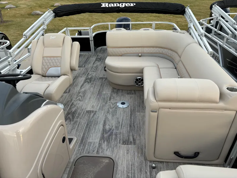 Slide: The Image of 2024 Ranger Reata 223FC boat interior with beige seating and modern design. - 7