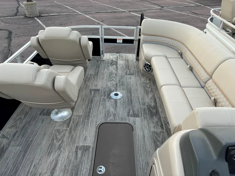 Slide: The Image of 2024 Ranger Reata 223FC boat interior with beige seating and wood-style flooring. - 8