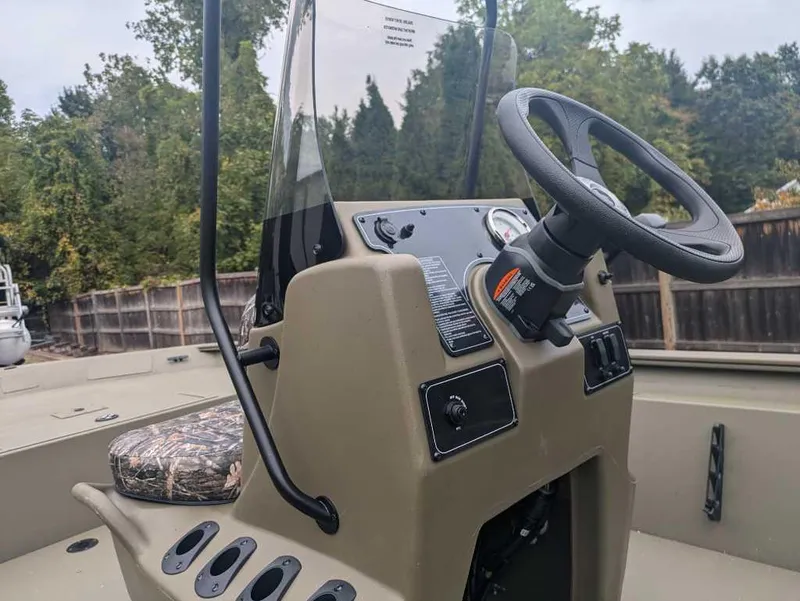 Slide: The Image of 2025 Tracker Grizzly 1860 CC boat console with steering wheel and camo seat. - 3