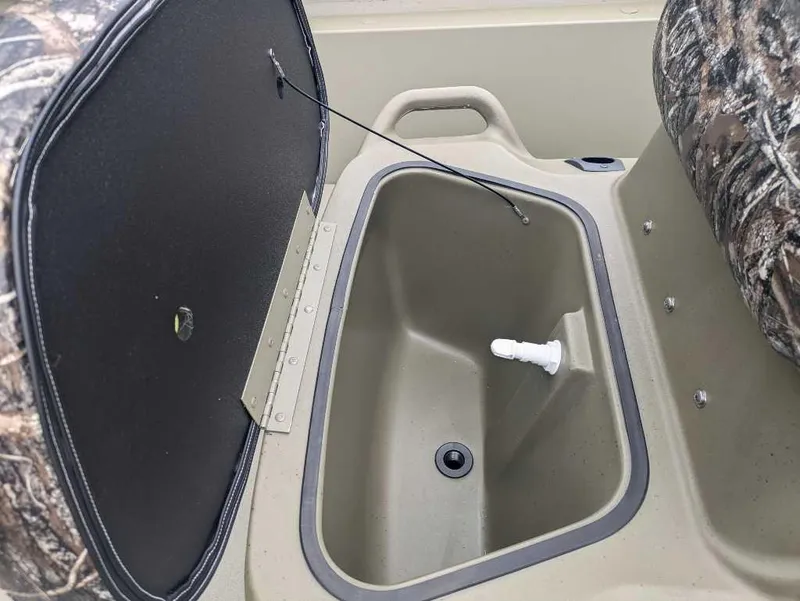 Slide: The Image of 2025 Tracker Grizzly 1860 CC boat storage compartment with open lid. - 4