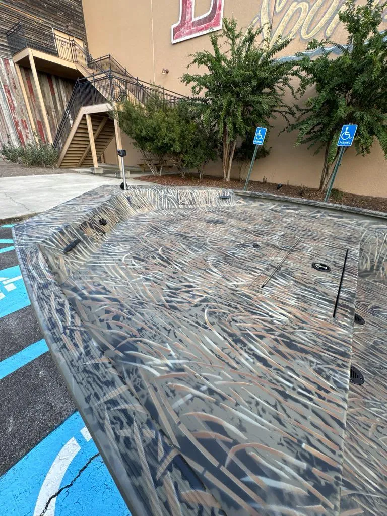 Slide: The Image of 2025 Tracker Grizzly 1860 CC boat with camouflage design in a parking area. - 4