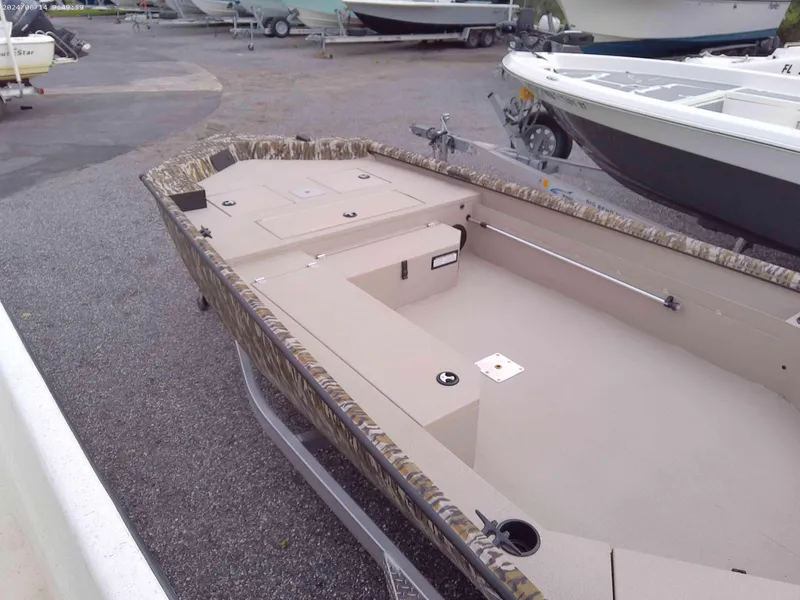 Slide: The Image of 2025 Avid 18 Commander boat with spacious interior, parked on gravel lot. - 4